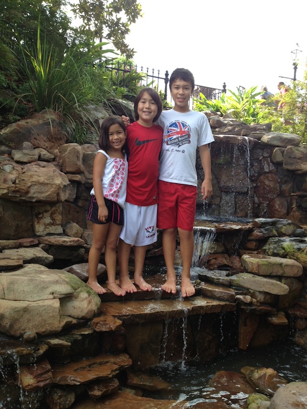 Taking off their shoes and wading in a wishing well waterfall!